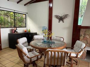 Nueva San SalvadorCabaña Vistas del Volcán的用餐室配有桌椅和蝴蝶壁。