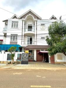 Ðưc TrọngHoàng Anh hotel的前面有标志的大型白色建筑