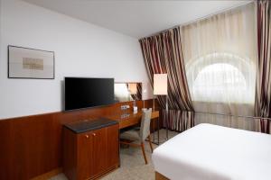 布达佩斯奥普拉K+K酒店的酒店客房配有一张床和一张书桌及一台电视