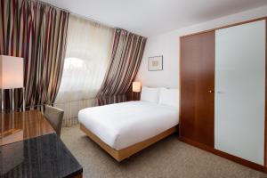 布达佩斯奥普拉K+K酒店的配有一张床和一张书桌的酒店客房