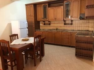 培拉特alexapartment的厨房配有桌椅和白色冰箱。