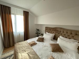 瓦马Casa cu Pitici的卧室配有带枕头的大型白色床