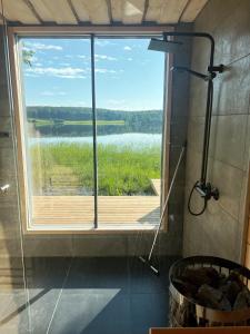于韦斯屈莱Lake Cottage with sauna (near City)的浴室设有大窗户,享有湖景
