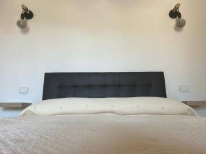 卡斯蒂里昂纳·德拉佩Agriturismo Il Giardino Degli Olivi Appartamenti的卧室内一张带黑色床头板的床