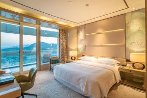 湖州湖州太湖喜来登温泉度假酒店的酒店客房设有一张大床和一张书桌。
