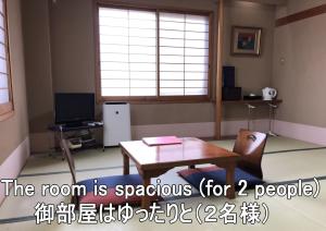 舞鹤市Ryokan Ginsuikaku - Vacation STAY 40409的客房设有桌子、书桌和窗户。