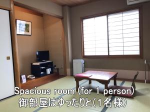 舞鹤市Ryokan Ginsuikaku - Vacation STAY 40409的一间设有桌子和窗户的客房