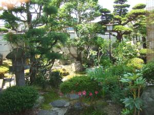 舞鹤市Ryokan Ginsuikaku - Vacation STAY 40409的种满鲜花和树木的花园,街道灯