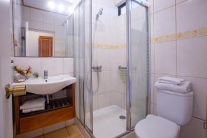 安加罗阿Hostal Uruhao的带淋浴、卫生间和盥洗盆的浴室
