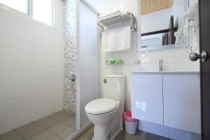 花莲市花莲上海时光民宿的白色的浴室设有卫生间和水槽。