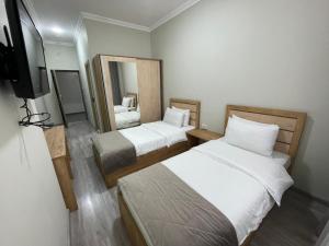 塔什干Airport Hotel 24的小房间设有两张床和电视