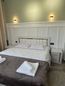 卡拉科尔Vavilon的卧室配有一张白色大床,上面有毛巾