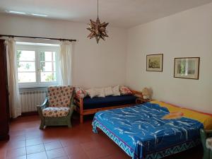 普罗基奥la raganella - appartamento的卧室配有床、椅子和窗户。