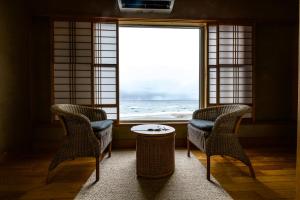 函馆若松温泉旅馆的窗户客房内的两把椅子和一张桌子