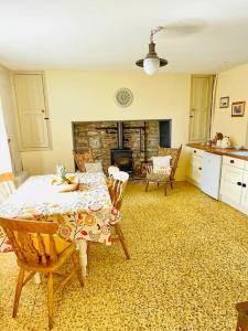 斯奇博瑞恩Idyllic Family farmhouse in beautiful West Cork的客厅配有桌椅和壁炉