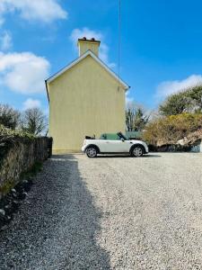 斯奇博瑞恩Idyllic Family farmhouse in beautiful West Cork的停在教堂前的白色汽车
