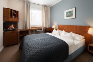 汉堡巴塞尔酒店的酒店客房配有一张床和一个壁炉。