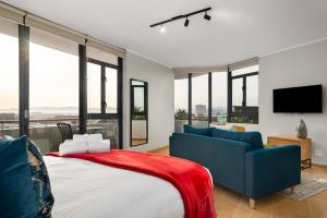 开普敦Urban Artisan Luxury Suites by Totalstay的一间卧室配有一张床、一张沙发和窗户。