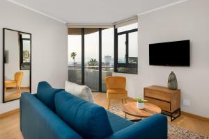开普敦Urban Artisan Luxury Suites by Totalstay的客厅配有蓝色的沙发和电视