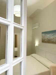 奇尼斯Conte125的一间卧室配有床、窗户和绘画