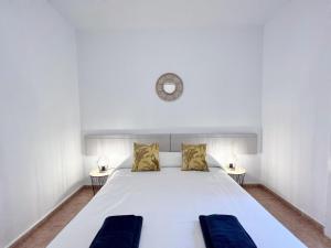 巴塞罗那Villa Olimpica Beach的卧室配有白色的床和墙上的时钟