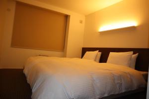 饭山市Aki's Apartments Madarao的卧室配有白色的床和大窗户