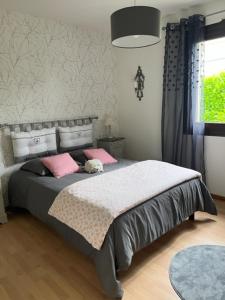 LavardacLes voyages de Louison的一间卧室配有带粉红色枕头的床
