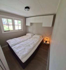 尼乌芬Park De Driesprong的一间卧室配有一张带白色床单的床和一扇窗户。