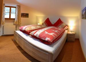 施利尔塞Haus Sonnbichl的一间卧室配有红色和白色枕头的床