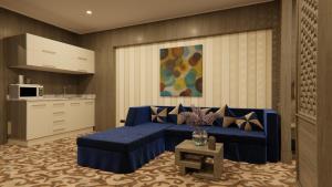 科威特AlHamra Hotel Kuwait的一间带蓝色沙发的客厅和一间厨房