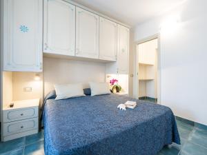 维拉西米乌斯翠绿乡村度假酒店的一间卧室配有蓝色的床和白色橱柜