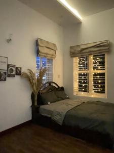 Thôn Mỹ PhướcLa Vie En Rose的一间卧室设有一张床和两个窗户。