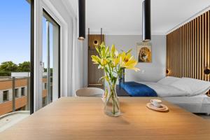 柏林Nena Apartments Berlin - Adlershof - "New Opening 2024"的房间里的一张木桌上一束黄色花