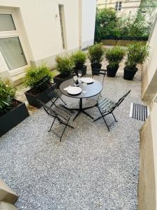汉堡3-Raum Apartment Quartier57 Hamburg-Eppendorf的庭院配有桌椅和植物