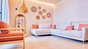 伏罗拉Azar Luxury Suites的客厅配有两张沙发和墙上的盘子