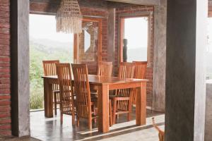 纳闽巴霍Bukit Cottage Pak Ansel的一间带木桌和椅子的用餐室