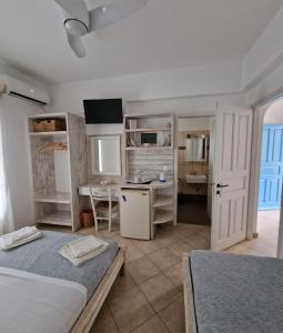 斯希努萨岛Harama hotel Schinoussa的一间带两张床和一张书桌的卧室以及一间厨房