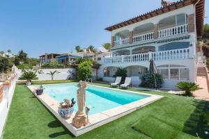 卡莱塔德贝莱斯Villa María con Piscina playa y vistas的一座带游泳池和房子的别墅