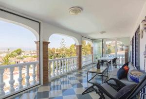 卡莱塔德贝莱斯Villa María con Piscina playa y vistas的客厅设有带桌椅的阳台