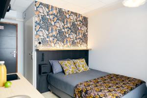 勒阿弗尔Smart Appart Le Havre 97的卧室配有一张带花卉壁纸的床铺。