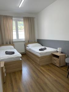 班斯卡-比斯特里察Ubytovanie HAMAR 17的一间卧室设有两张床、一张桌子和一个窗口。
