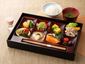 福冈JR九州福冈花博酒店的桌上的盘子,包括寿司和米饭