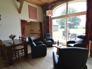 GeesterenQuaint Farmhouse in Geesteren with Meadow View的一间带桌椅的客厅和一间卧室