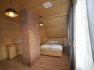 OsiekWooden Holiday Home in Skrzynia with Terrace的小木屋内的一个床位