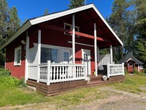 罗瓦涅米Vikajärvi Lake View Experience Igloos的一间红色的小房子,设有白色门廊和门廊