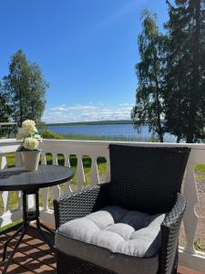 罗瓦涅米Vikajärvi Lake View Experience Igloos的一张柳条椅,坐在阳台上,配有桌子
