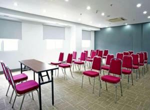 巨港Monoloog Hotel Palembang的一间会议室,配有红色的椅子和桌子