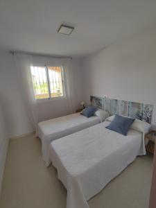维拉EDA Paradise Vera Playa的白色客房的两张床,设有窗户