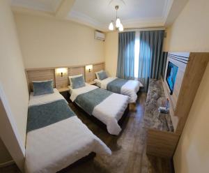 甘贾Old City Ganja的一间酒店客房,设有两张床和电视