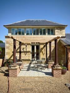 奥克姆Normanton Park House - Luxury Rutland Water Home的一座石屋,设有木制凉亭